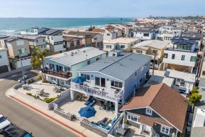 an aerial view of a city with houses and the ocean at Ocean Breeze II by AvantStay Steps to the Beach in Newport Beach