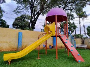 - une aire de jeux avec toboggan dans la pelouse dans l'établissement Pousada Terraço, à Socorro