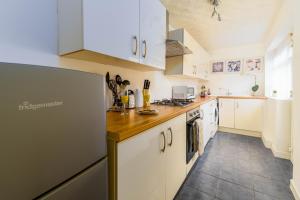 a kitchen with white cabinets and a refrigerator at Liverpool City Haven-Dane Street in Liverpool