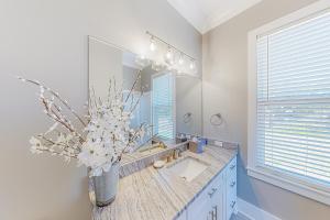 a bathroom with a sink and a vase of flowers at The Ruth Retreat in Gulfport +18 photos