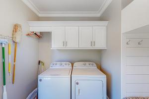 a white laundry room with a washer and dryer at The Ruth Retreat in Gulfport