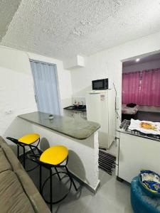 La cuisine est équipée d'une table, de 4 chaises et d'un réfrigérateur. dans l'établissement Apartamento Aconchegante Mobiliado, ZN - Cod 02, à São Paulo