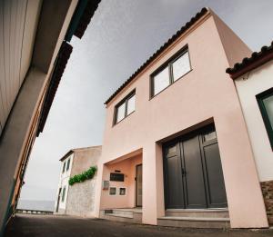 una casa con puertas negras en una calle en Cozy Seaside Studio Apartment C - Faraway, en Lagoa