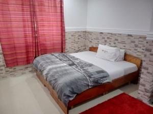 1 dormitorio con 1 cama con pared de ladrillo en Cheerful and peaceful 4-bedrooms house, en Koforidua