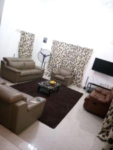 Sala de estar con 2 sofás y TV en Cheerful and peaceful 4-bedrooms house, en Koforidua