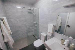 a bathroom with a shower and a toilet and a sink at Delightful Seaside Studio Apartment D - Faraway in Lagoa