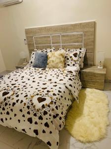 a bed with a cow print comforter and a rug at Heaven Home 2 in Dakar