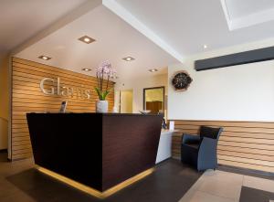 a lobby of a salon with a counter and chairs at Hôtel Glanis in Gland