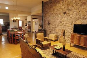 a living room with a stone wall at La Pausa. Casa de campo in Deán Funes