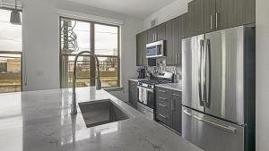 休斯頓的住宿－Landing - Modern Apartment with Amazing Amenities (ID1403X403)，厨房配有不锈钢冰箱和水槽