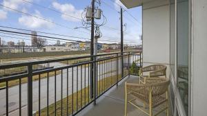 un balcón con 2 sillas y vistas a un tren en Landing - Modern Apartment with Amazing Amenities (ID1403X403) en Houston