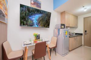 a kitchen with a table and a refrigerator at MALL OF ASIA Condo with Balcony Facing Pool @ Shore2 in Manila