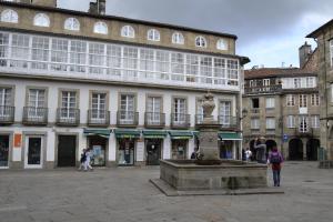 a fountain in a square in front of a building at Apartamentos Turísticos Pacios in Santiago de Compostela