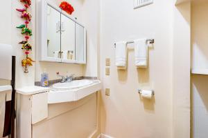 La salle de bains blanche est pourvue d'un lavabo et d'un miroir. dans l'établissement The Garden Home, à Issaquah