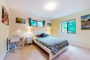a bedroom with a bed and a desk and windows at The Garden Home in Issaquah