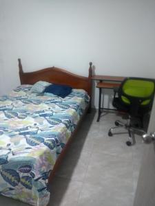 a bedroom with a bed and a desk and a chair at Hostal Turístico Ninfa del Mar in Manizales