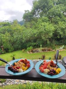 two plates of food sitting on a wooden table at Espaço Isha Canelinha in Canelinha +56 photos