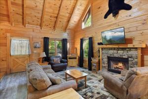 ein Wohnzimmer mit einem Kamin in einer Hütte in der Unterkunft 5br Retreat With Hot Tub, Fireplace & Game Room! in Pigeon Forge