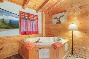 a bathroom with a tub in a cabin at 5br Retreat With Hot Tub, Fireplace & Game Room! in Pigeon Forge