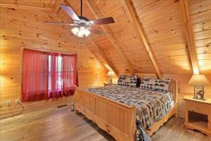 1 dormitorio con 1 cama y ventilador de techo en 5br Retreat With Hot Tub, Fireplace & Game Room! en Pigeon Forge