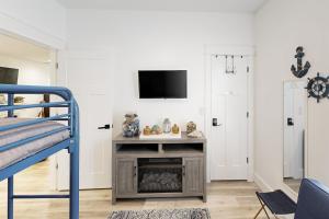 a bedroom with a tv on a white wall at Carmel Cottage in Foley