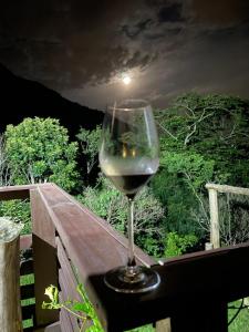 een glas wijn op een reling bij Espaço Isha in Canelinha