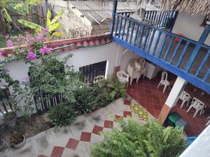 un balcón con una escalera azul y flores y plantas en Milimar Hostal, en San Onofre