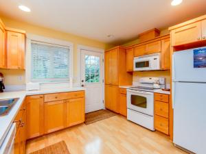 a kitchen with wooden cabinets and a white refrigerator at Becalmed MCA#1653 in Manzanita