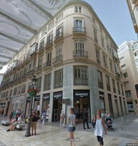 un gran edificio con gente caminando delante de él en Suites Larios en Málaga