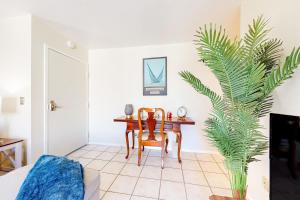 ein Wohnzimmer mit einem Tisch und einer Palmenpflanze in der Unterkunft Sail Bay Hideaway in San Diego
