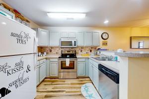 a kitchen with white cabinets and a stove top oven at The Palms --- 36507 Palm Dr #2203 in Rehoboth Beach