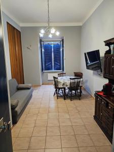 a living room with a table and chairs and a tv at Fiuggiamo House in Fiuggi