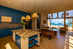 a kitchen with blue cabinets and a living room at Casa Colibrí in Máncora
