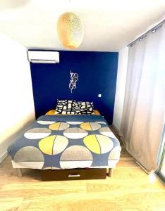 1 dormitorio con 1 cama con pared azul en maison avec spa et salle de projection, en Cournonterral