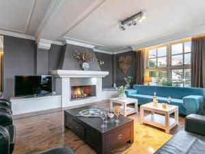 Molenzicht في Moergestel: غرفة معيشة مع أريكة زرقاء ومدفأة
