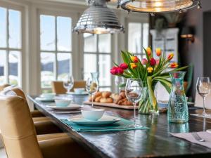 Molenzicht في Moergestel: طاولة غرفة الطعام مع الزهور وكؤوس النبيذ