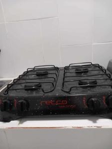 a black stove top sitting on top of a stove at PAZ Y BIEN BACKPACKERS - HABITACIÓN COMPARTIDA MIXTA EN MIRAFLORES DE FAMILIA EVANGÉLICA CON PRINCIPIOS Y VALOREs in Lima