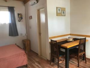 Cette petite chambre comprend une table, des chaises et un lit. dans l'établissement FINCA URBANA departamentos, à Alta Gracia
