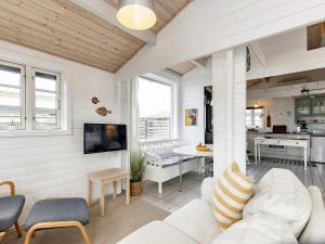 uma sala de estar com um sofá branco e uma mesa em Holiday home Karrebæksminde XLIV em Karrebæksminde