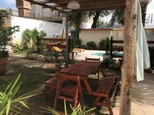 - une table de pique-nique en bois et des chaises dans la cour dans l'établissement FINCA URBANA departamentos, à Alta Gracia