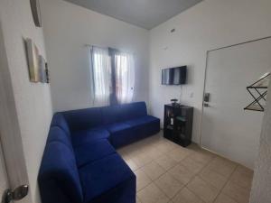 een blauwe bank in een woonkamer met een deur bij Max´s House in Ahuachapán