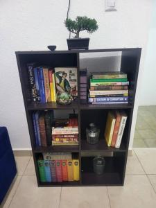 uma estante cheia de livros e um vaso de plantas em Max´s House em Ahuachapán