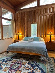 a bedroom with a bed and two lamps on tables at New Denver Lodge in New Denver