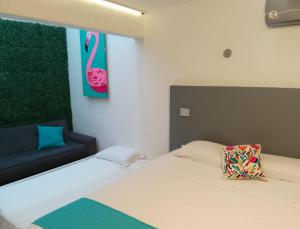 a bedroom with a bed and a chair and a pink towel at Hotel Downtown Merida in Mérida
