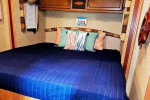 1 dormitorio con 1 cama azul en una cabaña en Kodesh Vacation Club, Boquerón Campers en Cabo Rojo