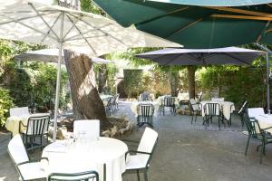 a group of tables and chairs with umbrellas at Logis Hôtels - Hôtel Restaurant du Midi in Revel