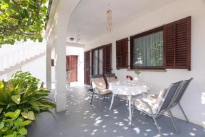 a patio with a white table and chairs at Apartments and rooms with parking space Njivice, Krk - 17010 in Njivice