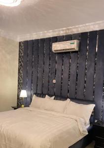 a bedroom with a large bed with a black headboard at منتجع ديم الهدا in Al Hada