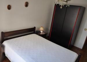 a bedroom with a bed and a black closet at Apartamento do Rio in Armação de Pêra