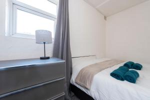 Un dormitorio con una cama con almohadas azules y una ventana en Harwich haven great for couples and contractors en Harwich